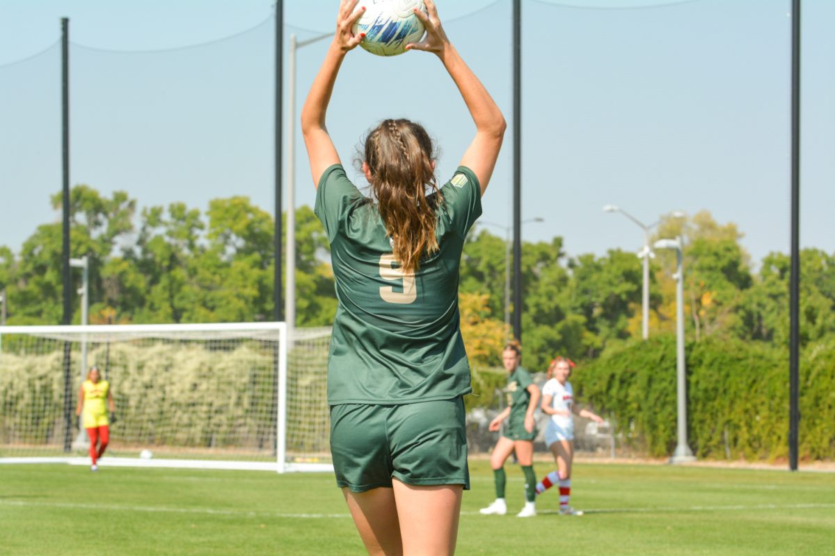 A soccer player throwing a soccer ball