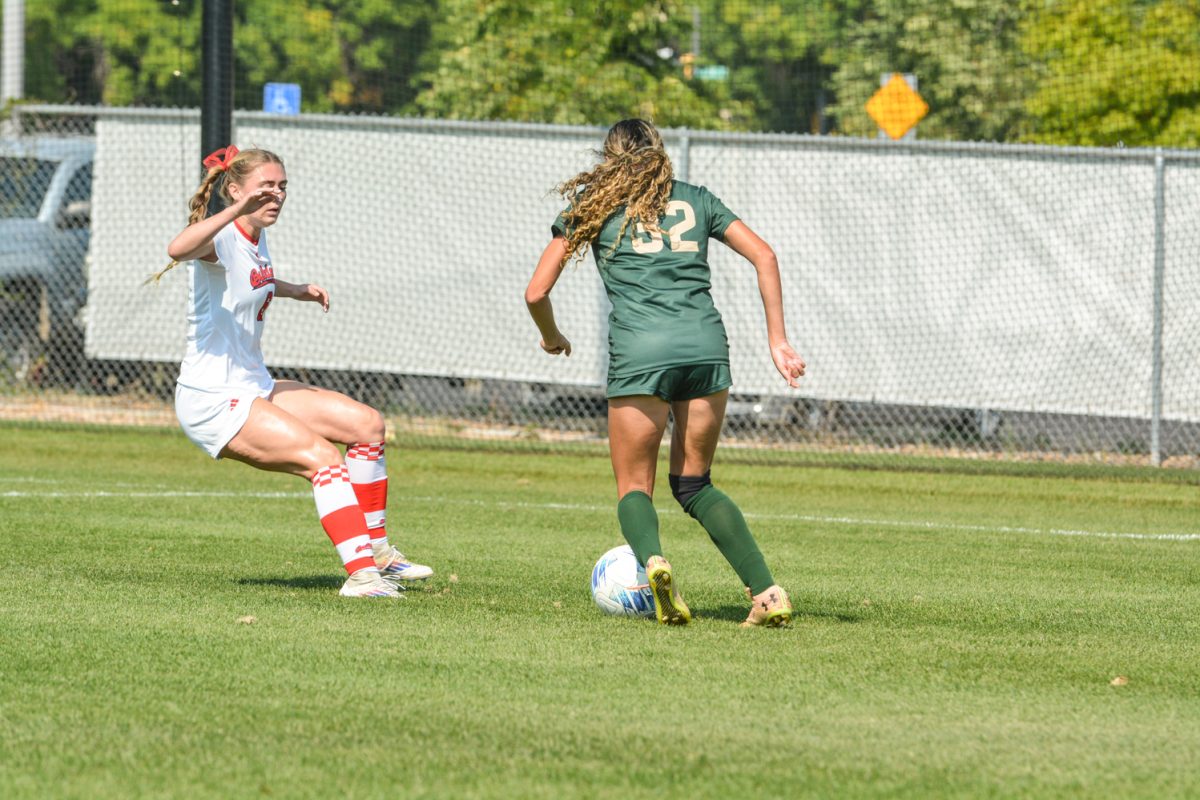 Two soccer players fighting over a soccer ball