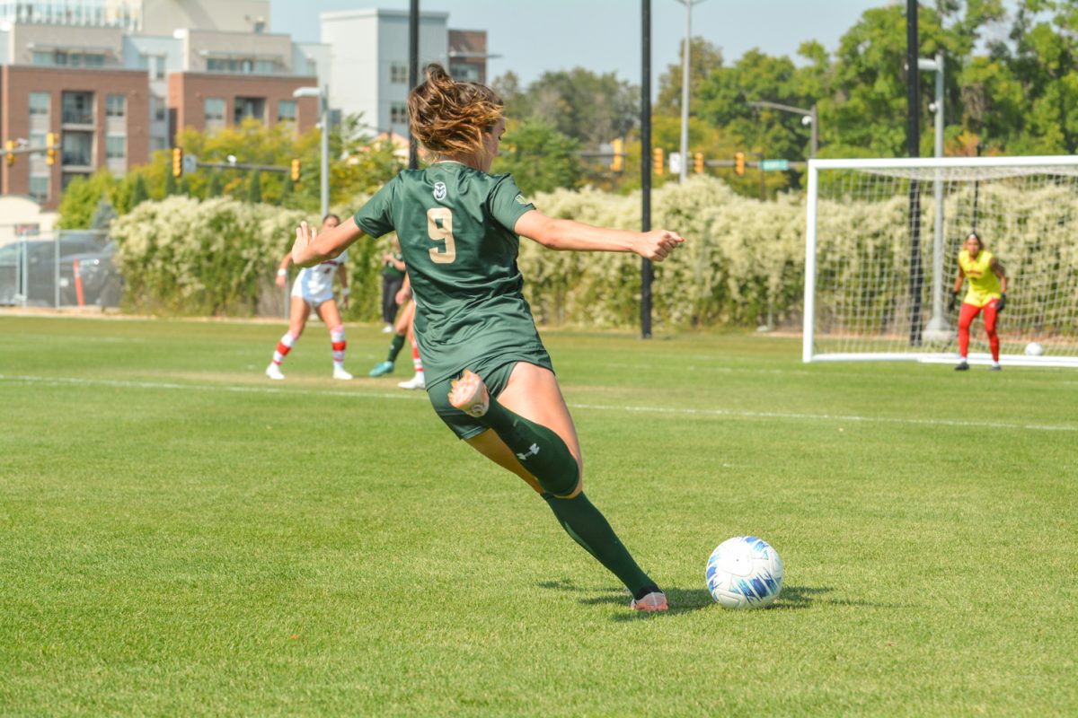 A soccer player kicks a soccer ball