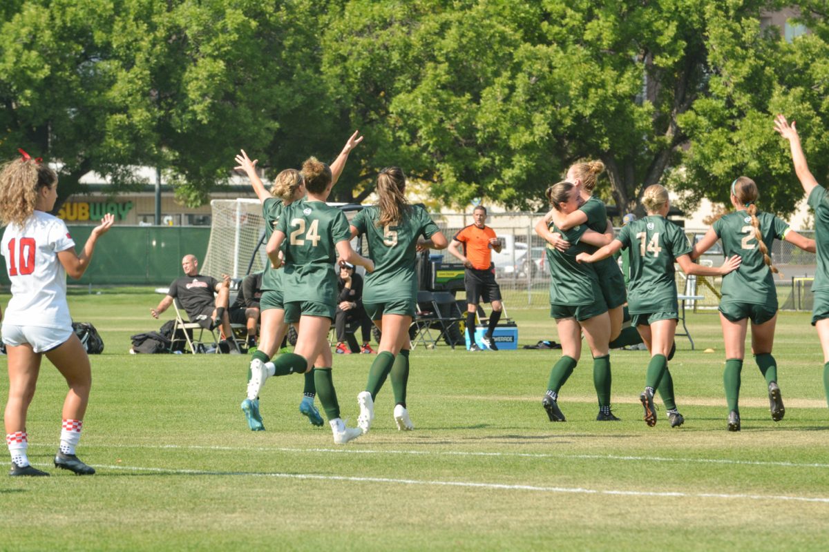 A soccer team jumping on each other celebrating