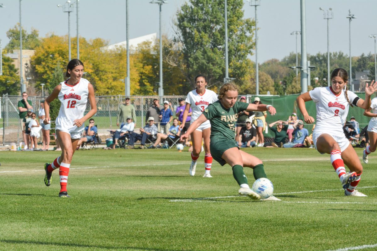 Three Fresno State soccer players surround a player on CSU's team to try and regain control of the ball.