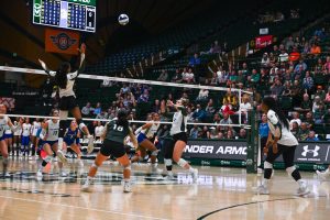 players in white and green long sleeves with black shorts on the court