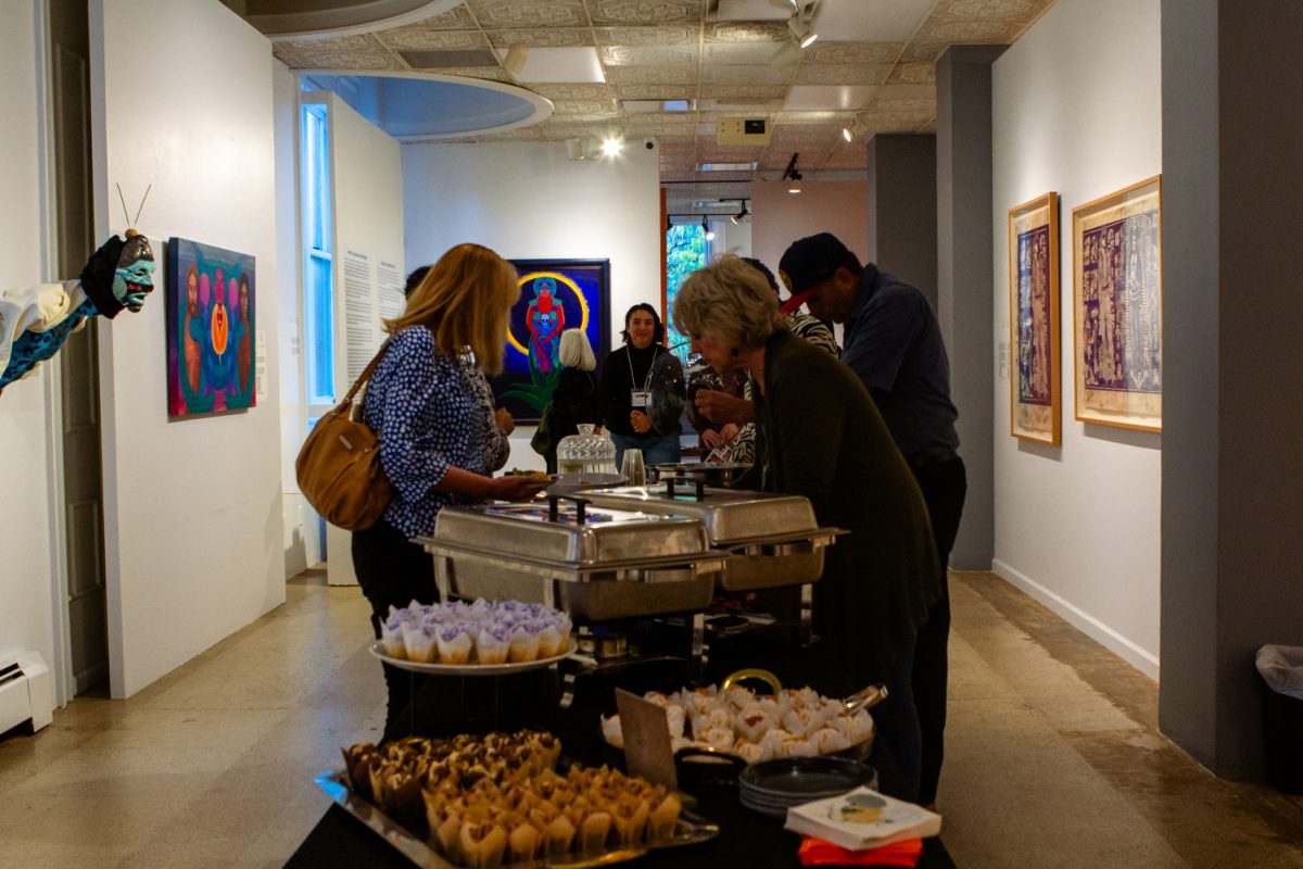 People serve themselves appetizers in a museum.