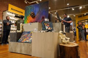 Paintings and skull figurines sit on wooden blocks of different heights.