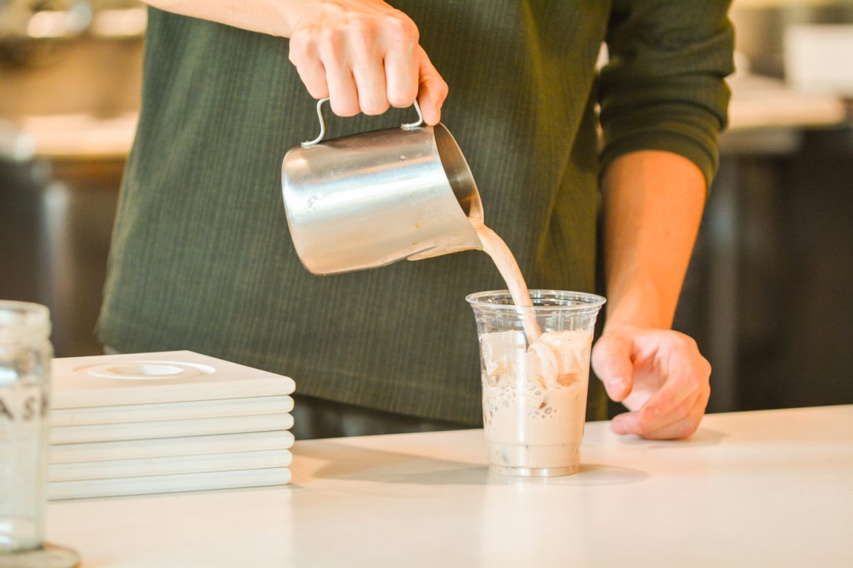 A chai drink being poured into a cup