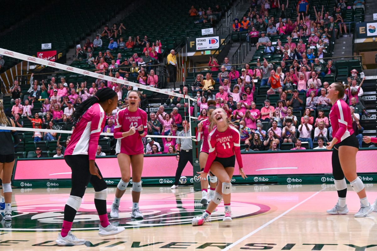 a group of players in pink and white long sleeves with black shorts celebrate