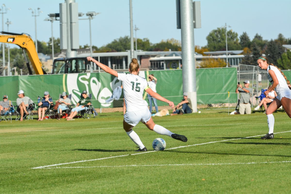 A soccer player kicking a soccer ball.