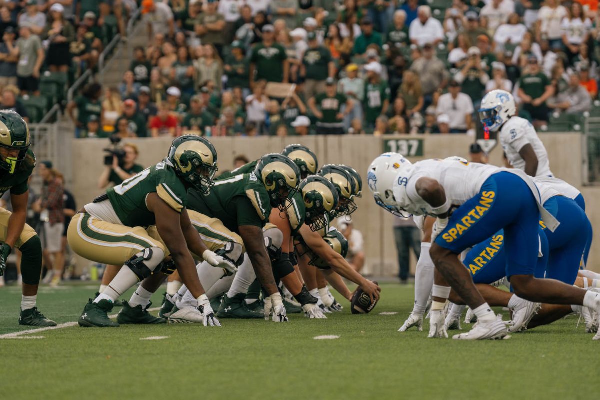 Football players line up, head to head, waiting for the start of play.