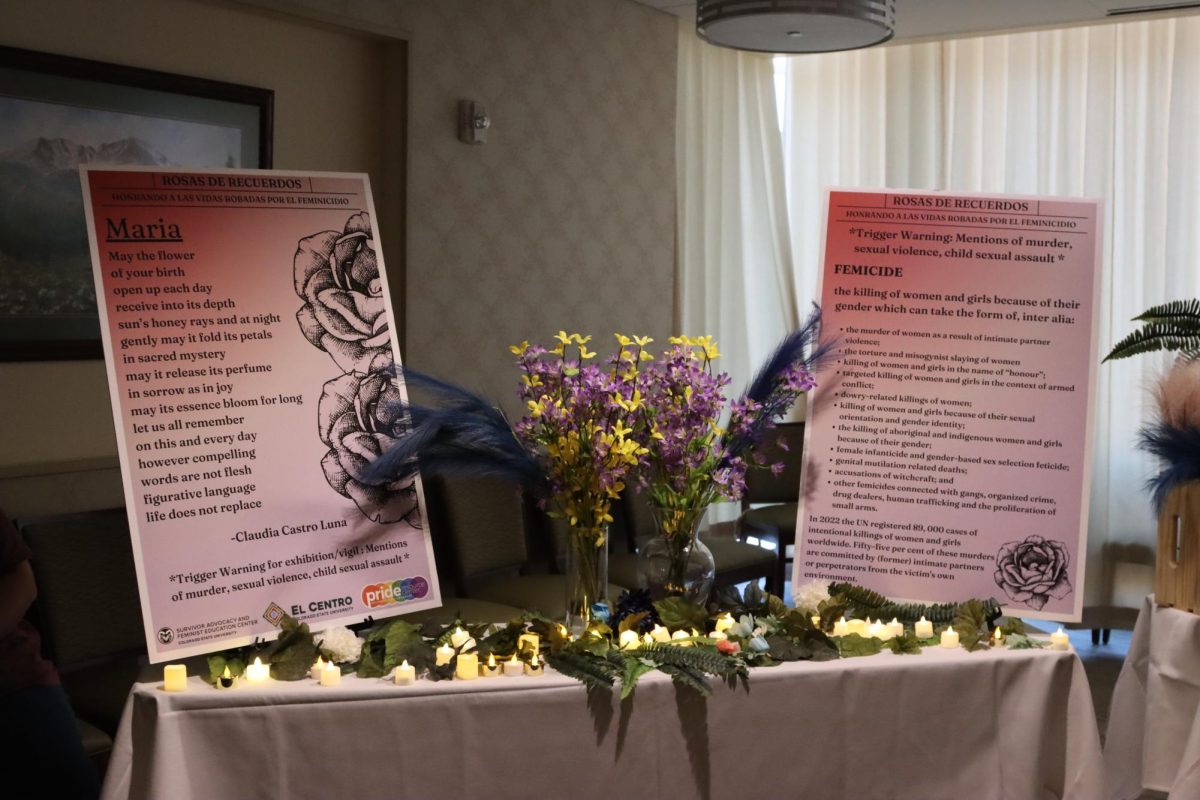 A table display with flowers, fake candles, and two pink informational placards.