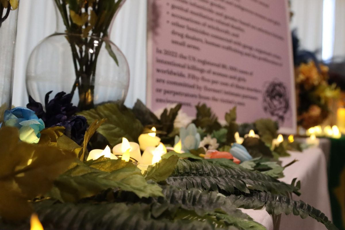 Tea candles resting in foliage on the entrance table of the Remembrance Roses: Honoring the Lives Stolen by Femicide memorial in the Lory Student Center on Oct. 15.  