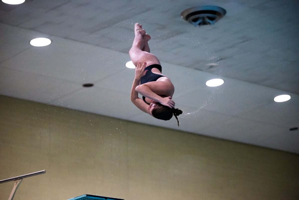 A diver spins midair after diving off a diving board.