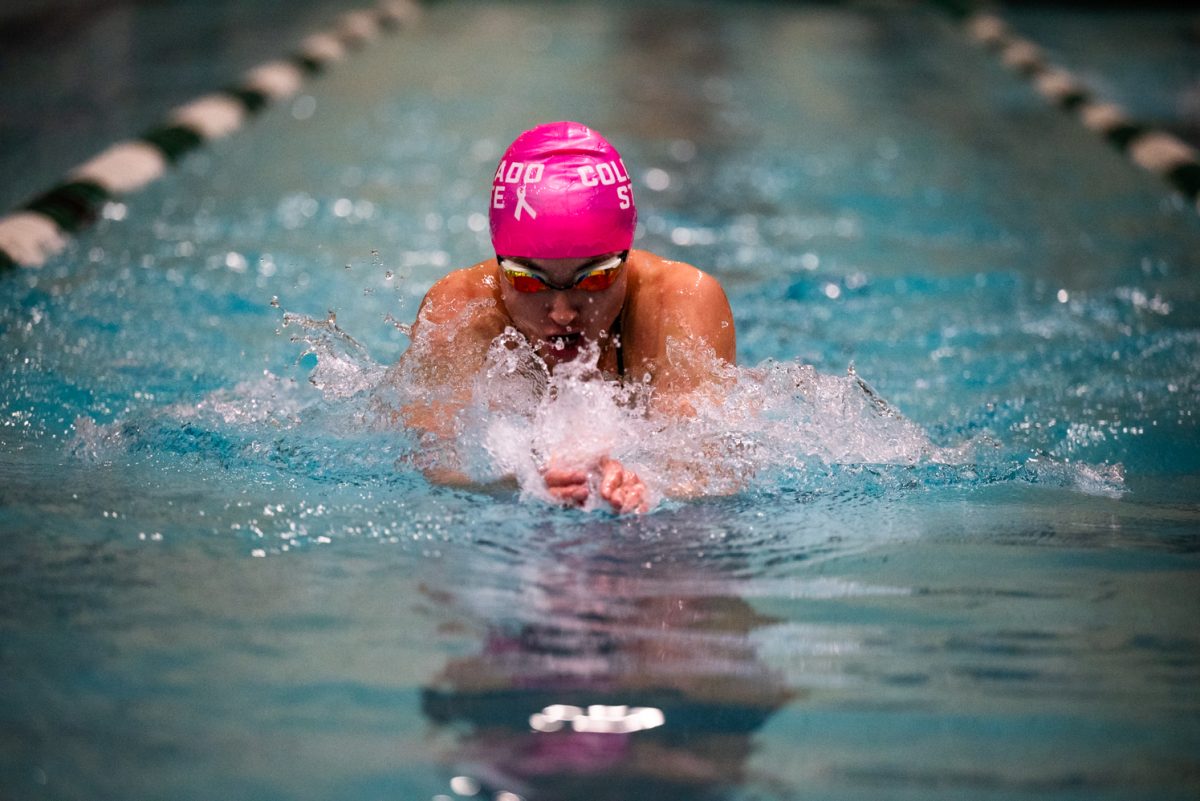 A swimmer comes up while swimming breaststroke.