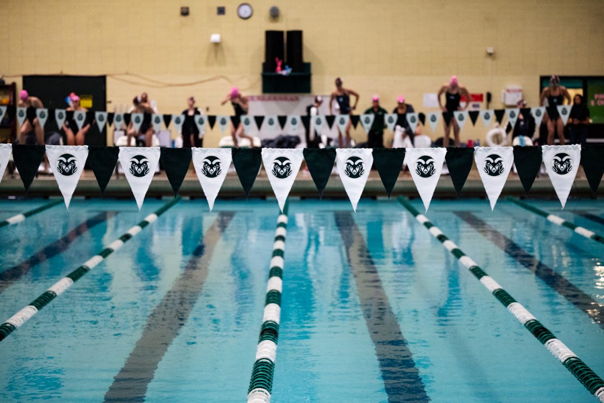 White and green flags with Colorado State University ram logos on them hung on a string over a pool.