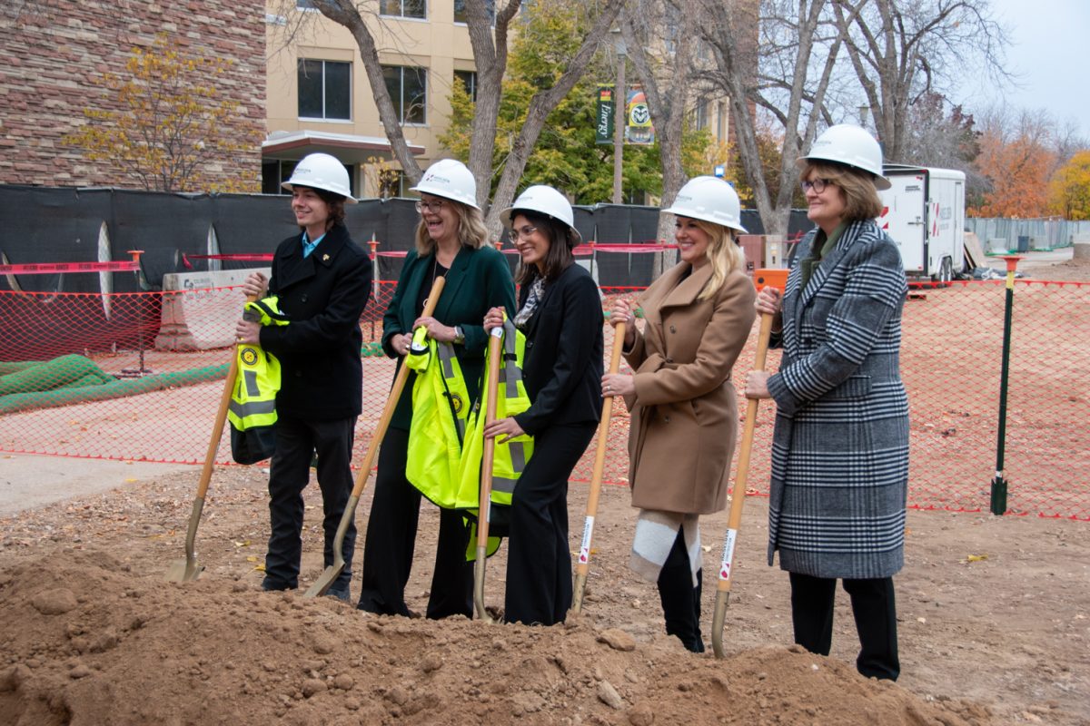 People in hard hats with shovels pose for a picture