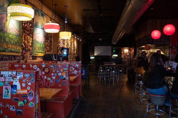 Red booths sit to the left and metal round bar stools are to the right of the picture at the counter.