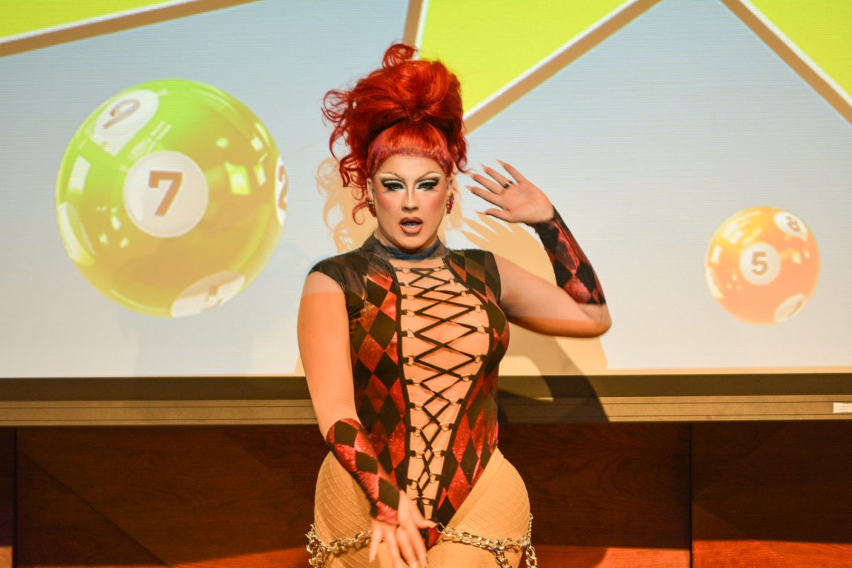 Performer in a red and black body suit posing.