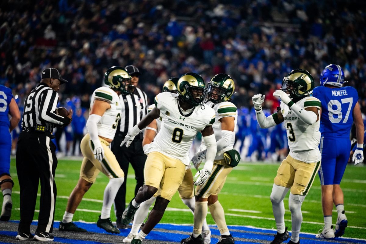 A football player in white and green runs while cheering.