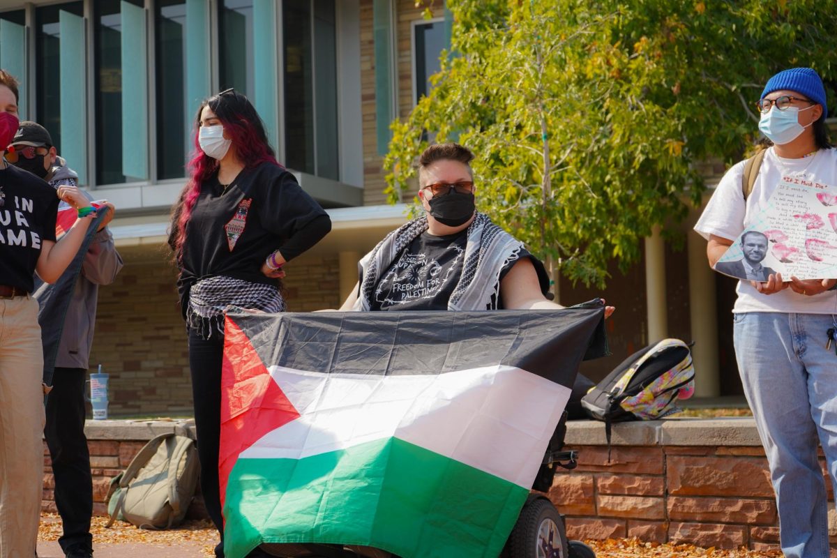 A member of Students for Justice Palestine on The Plaza Oct. 7 with the Palestinian flag during the Walk Out For Palestine demonstration. The demonstration was organized to mark one year since the start of the Israel-Hamas war. 