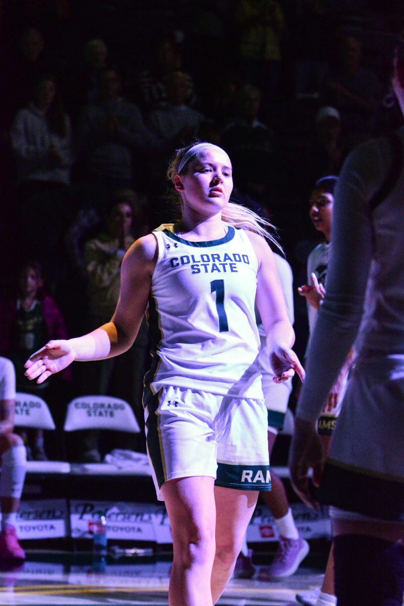 A player in a green and white jersey walking