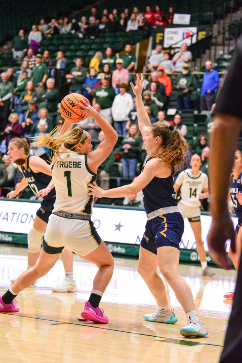 A player in a green and white jersey putting a ball above her head