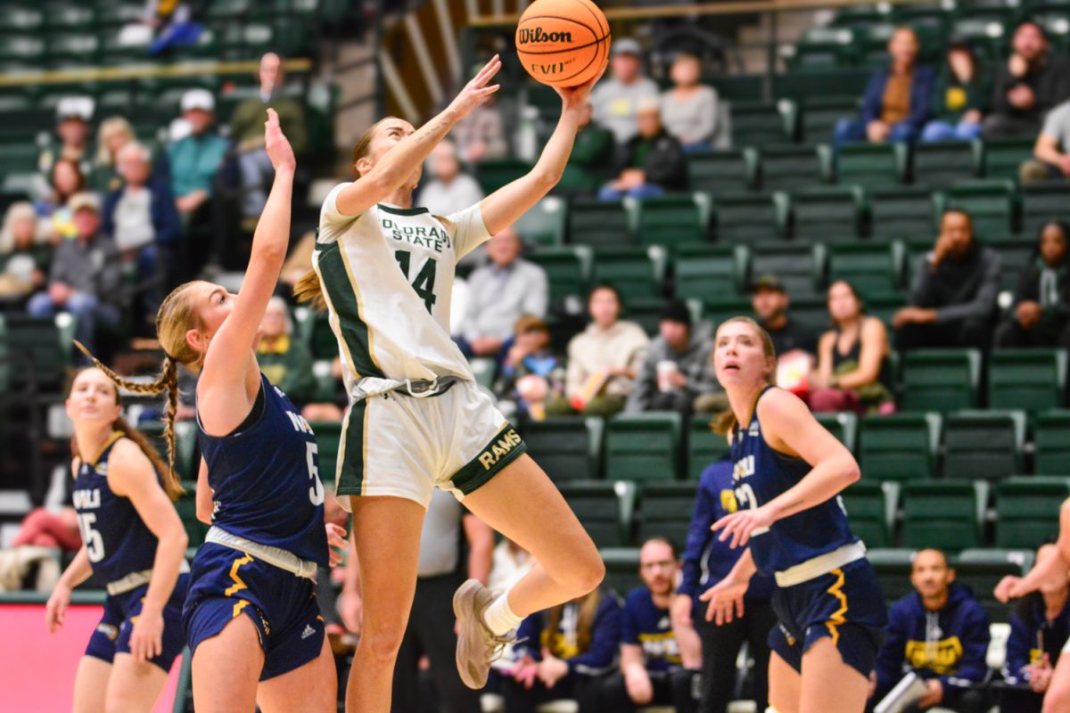 A player in a green and white jersey doing a layup