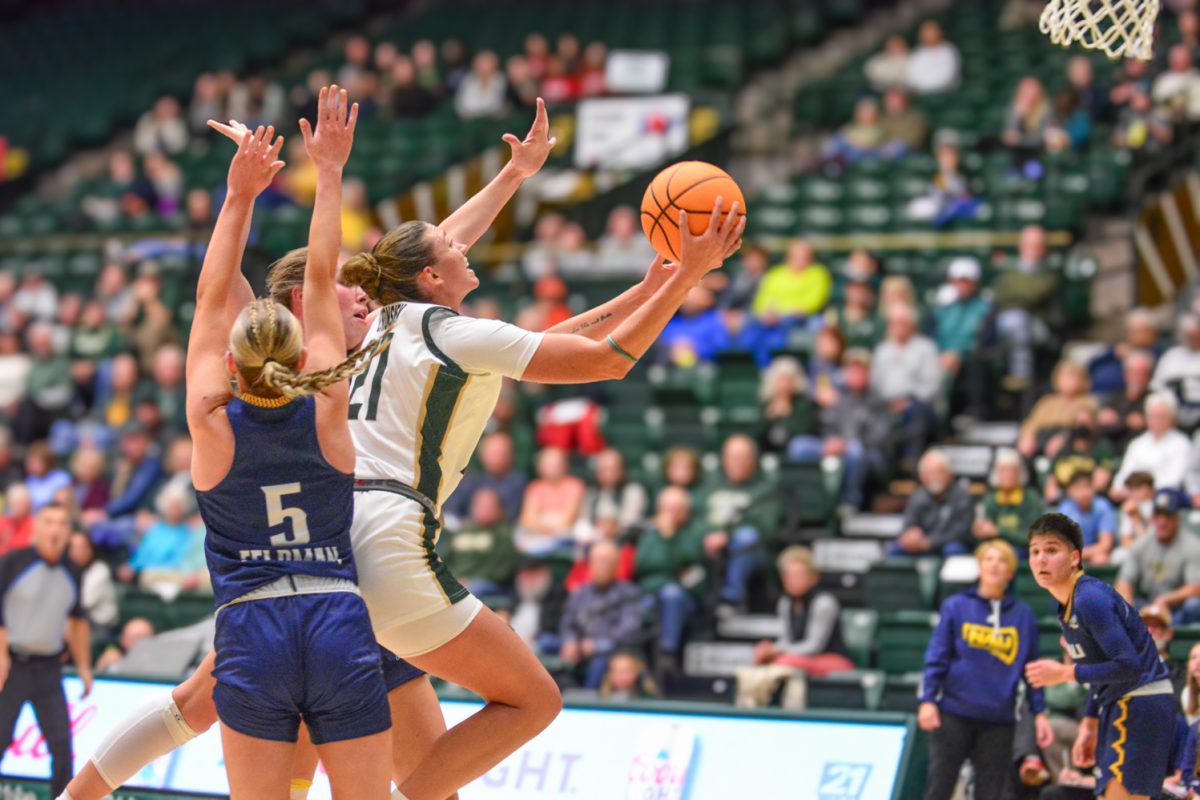 A player in a green and white jersey performing a layup