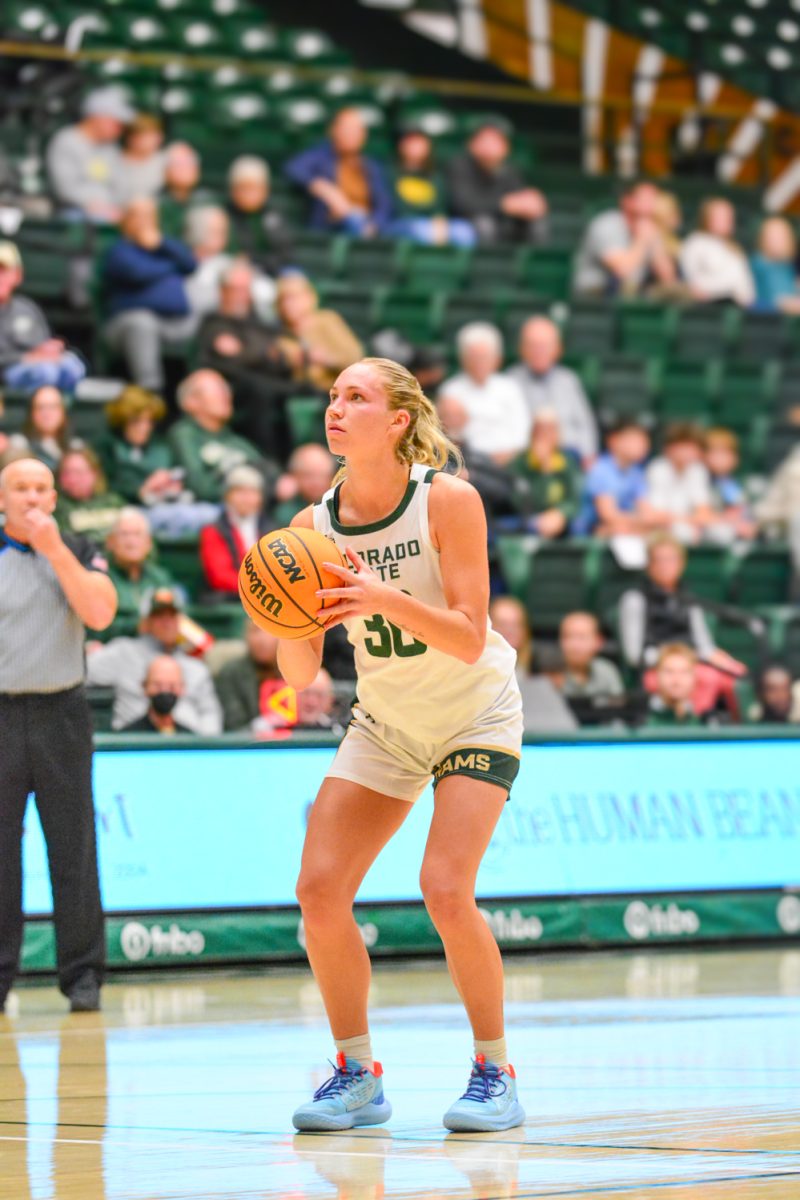 A player in a green and white jersey holding a ball