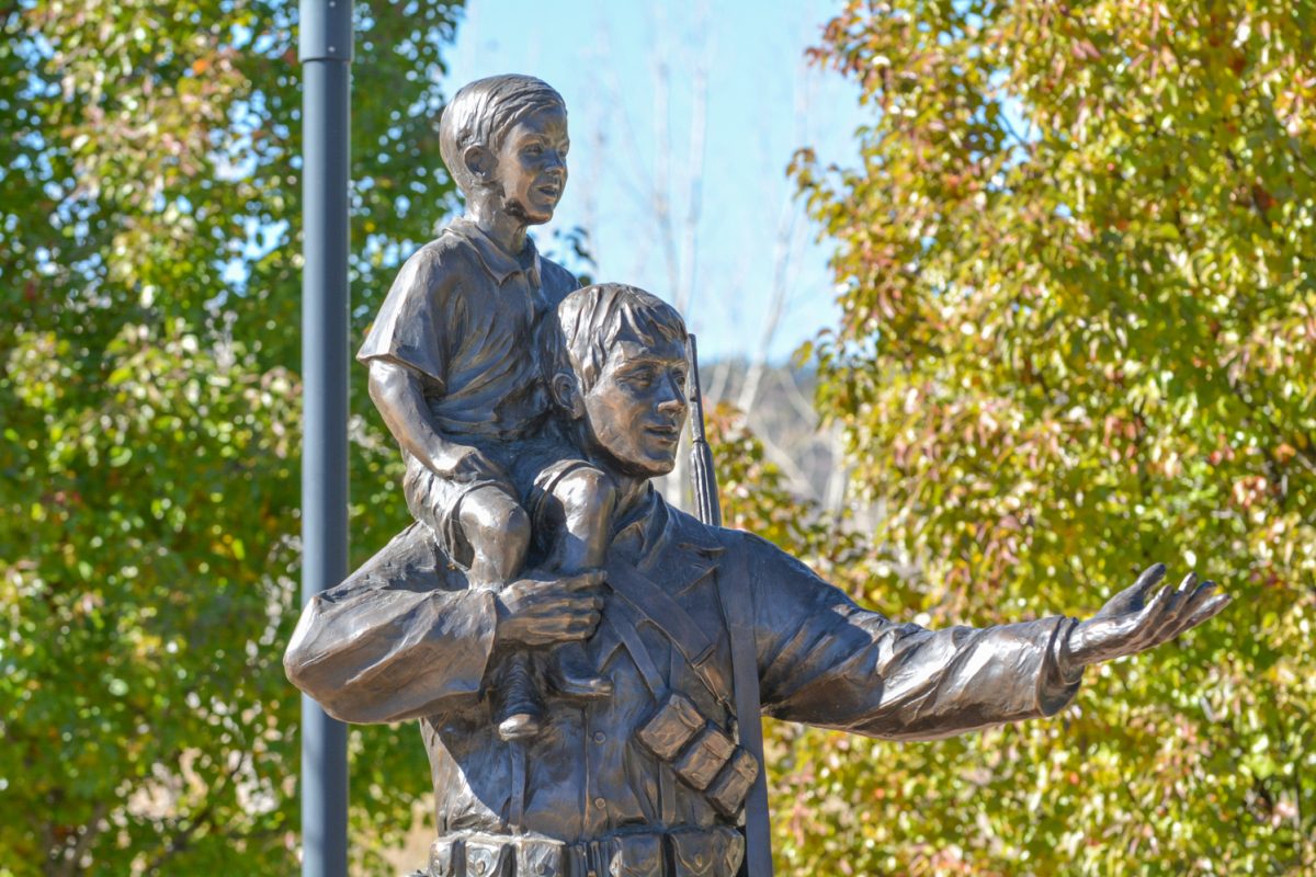 A statue of a soldier with a little boy on his shoulder