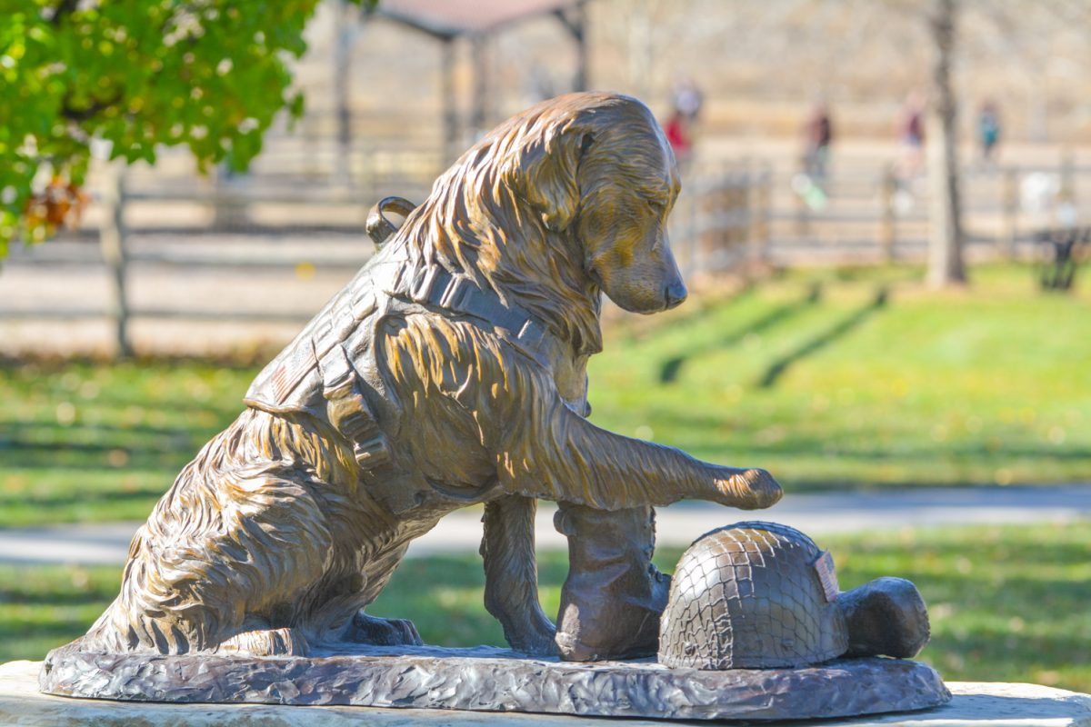 A statue of a dog hovering its paw on a soldiers hat Nov. 11. Diggs Brown donated this statue in honor of his service dog Arthur.