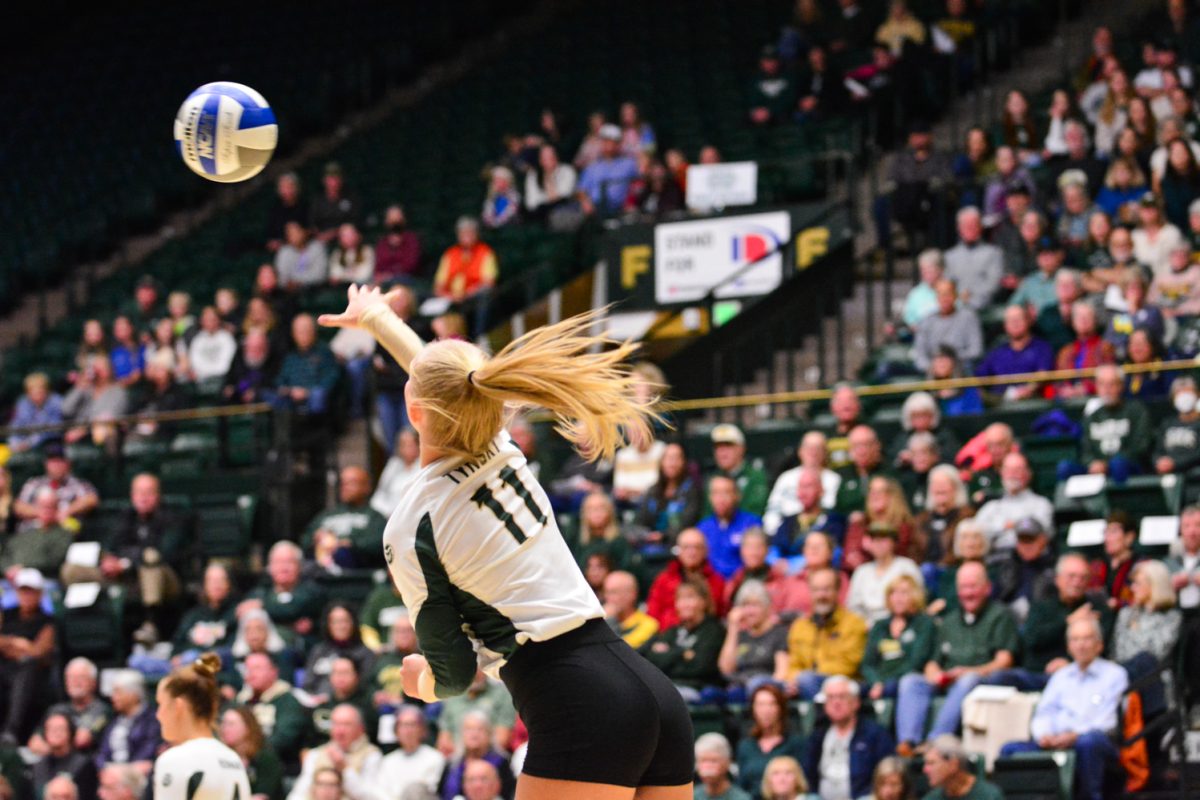 A player with a green and white jersey serving the ball