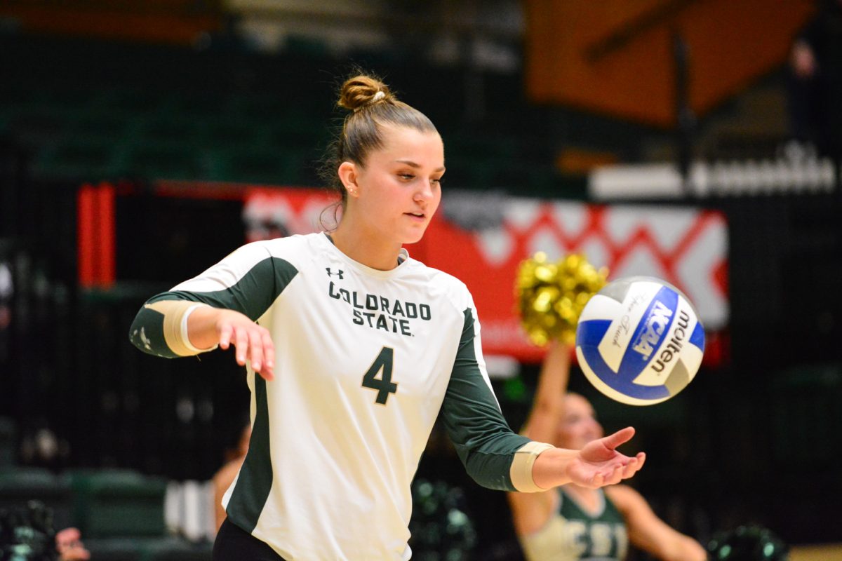 A player in a green and white jersey serving the ball