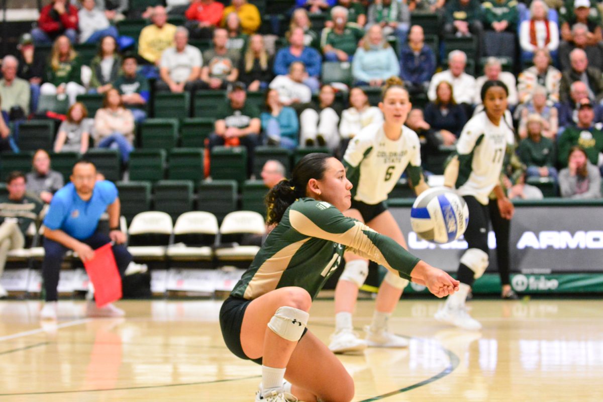 A player in a green and gold jersey hitting the ball