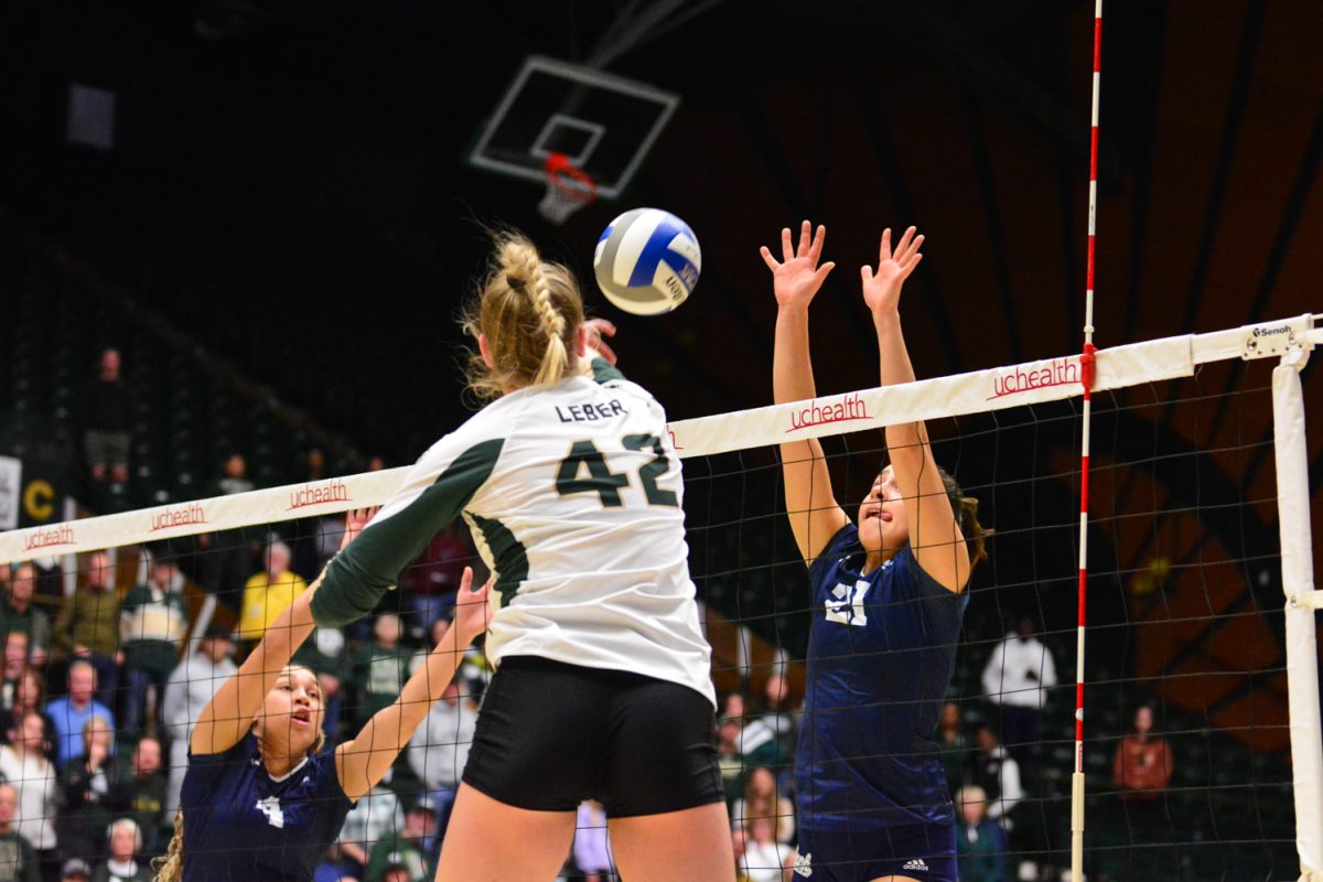 A girl in a green and white jersey striking the ball