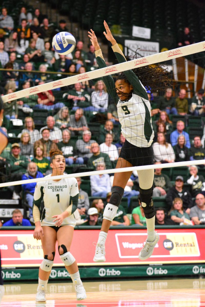 A player in a green and white jersey jumping for the ball.