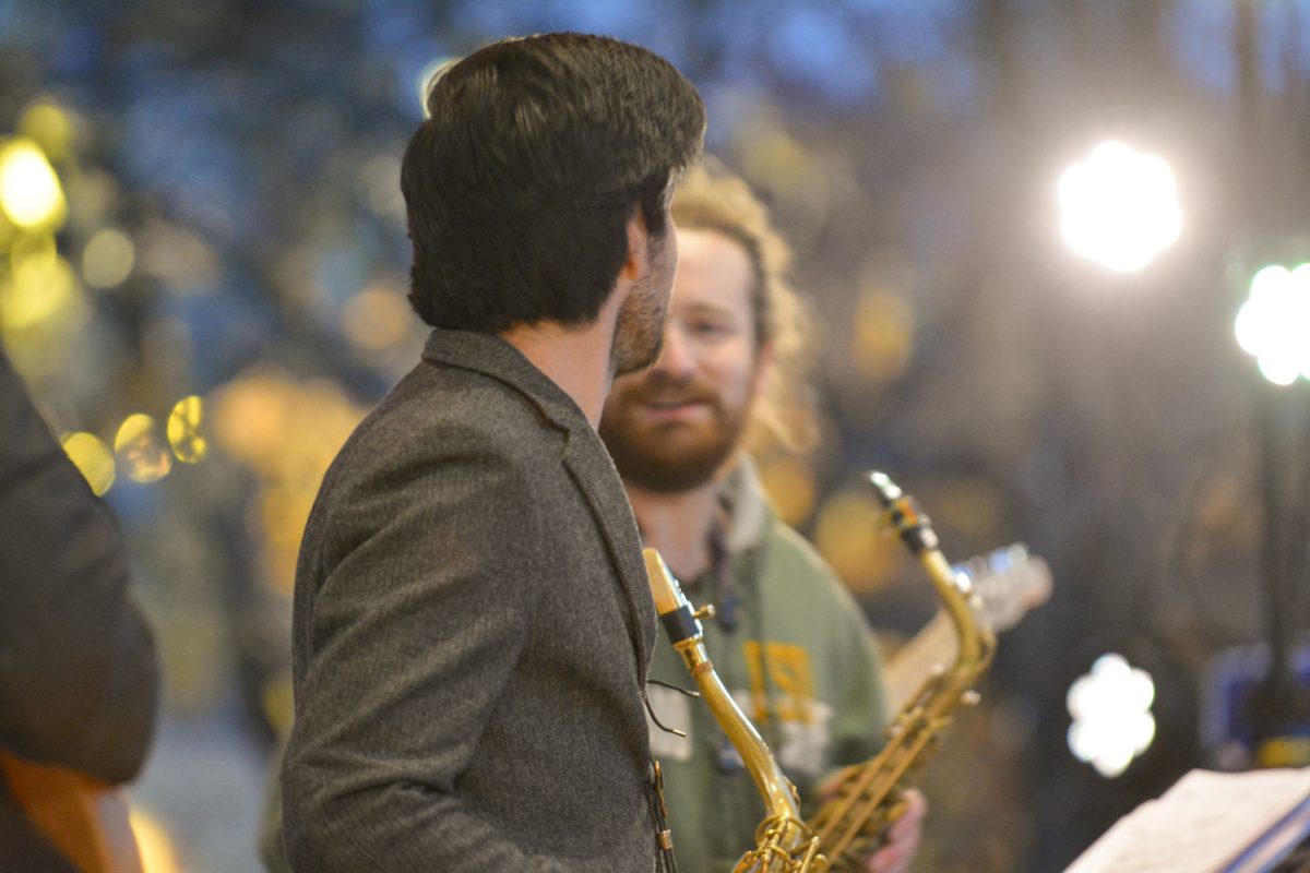 A guy with his back turned holding a saxaphone