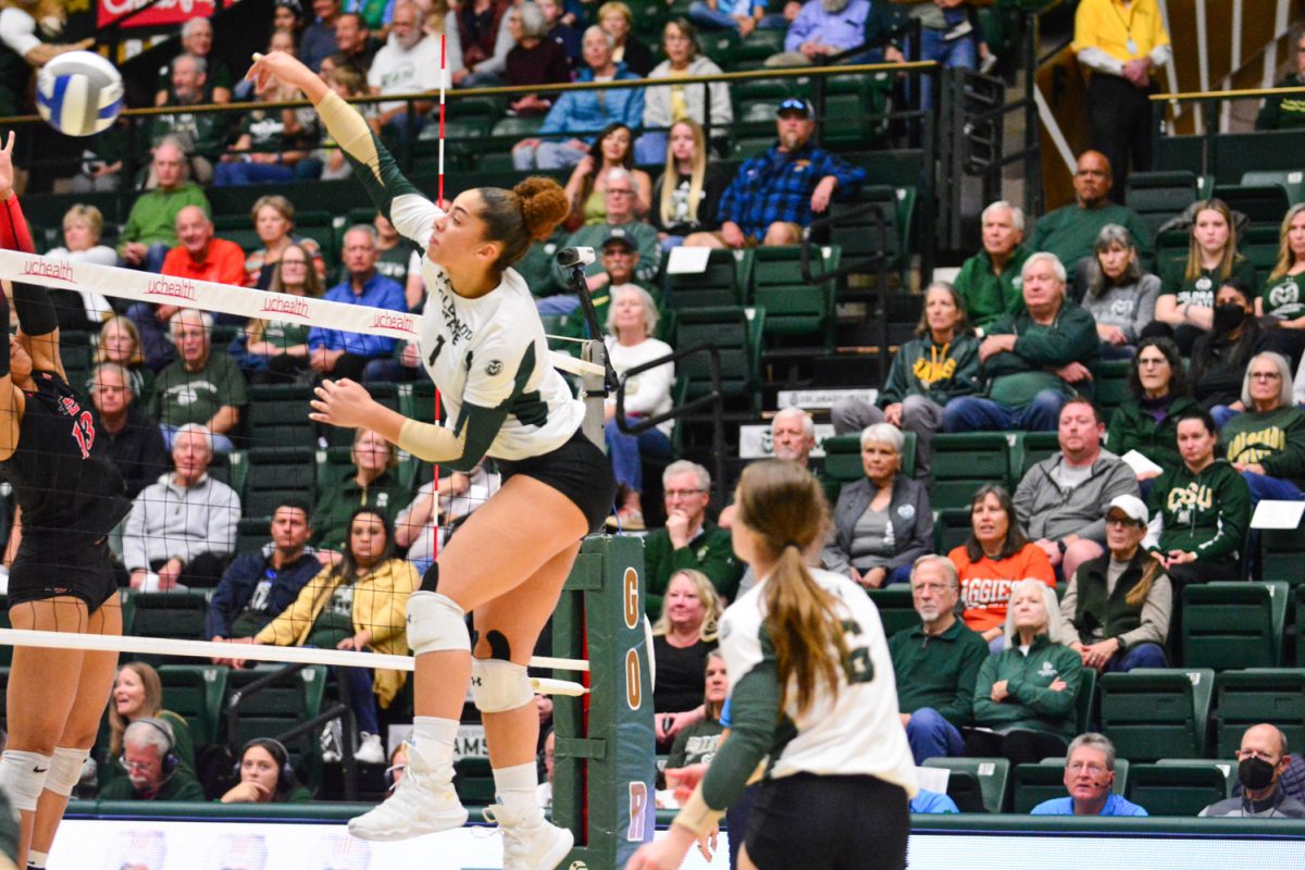 Girl in green and white jersey hitting the ball