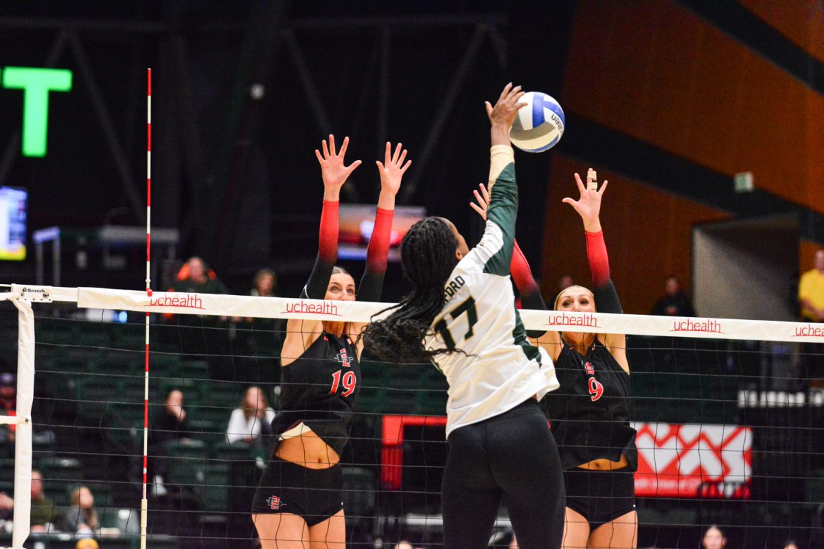 Girl in green and white jersey hitting the ball