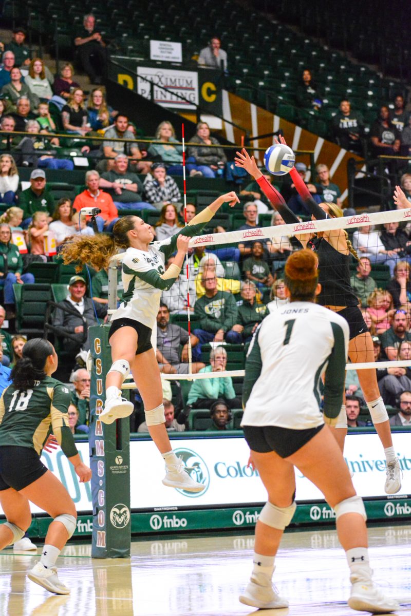 Girl in green and white jersey hitting the ball