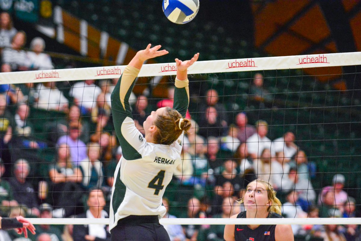 Girl in green and white jersey setting the ball