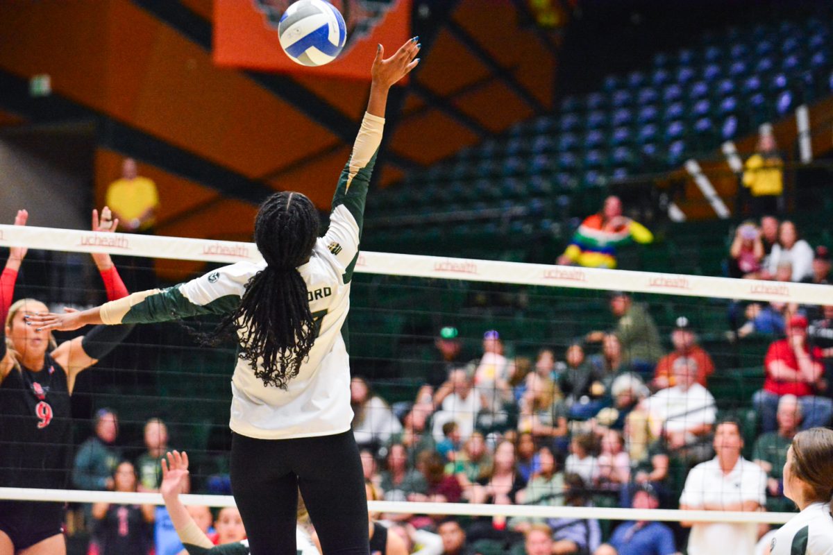 Girl in green and white jersey hitting the ball