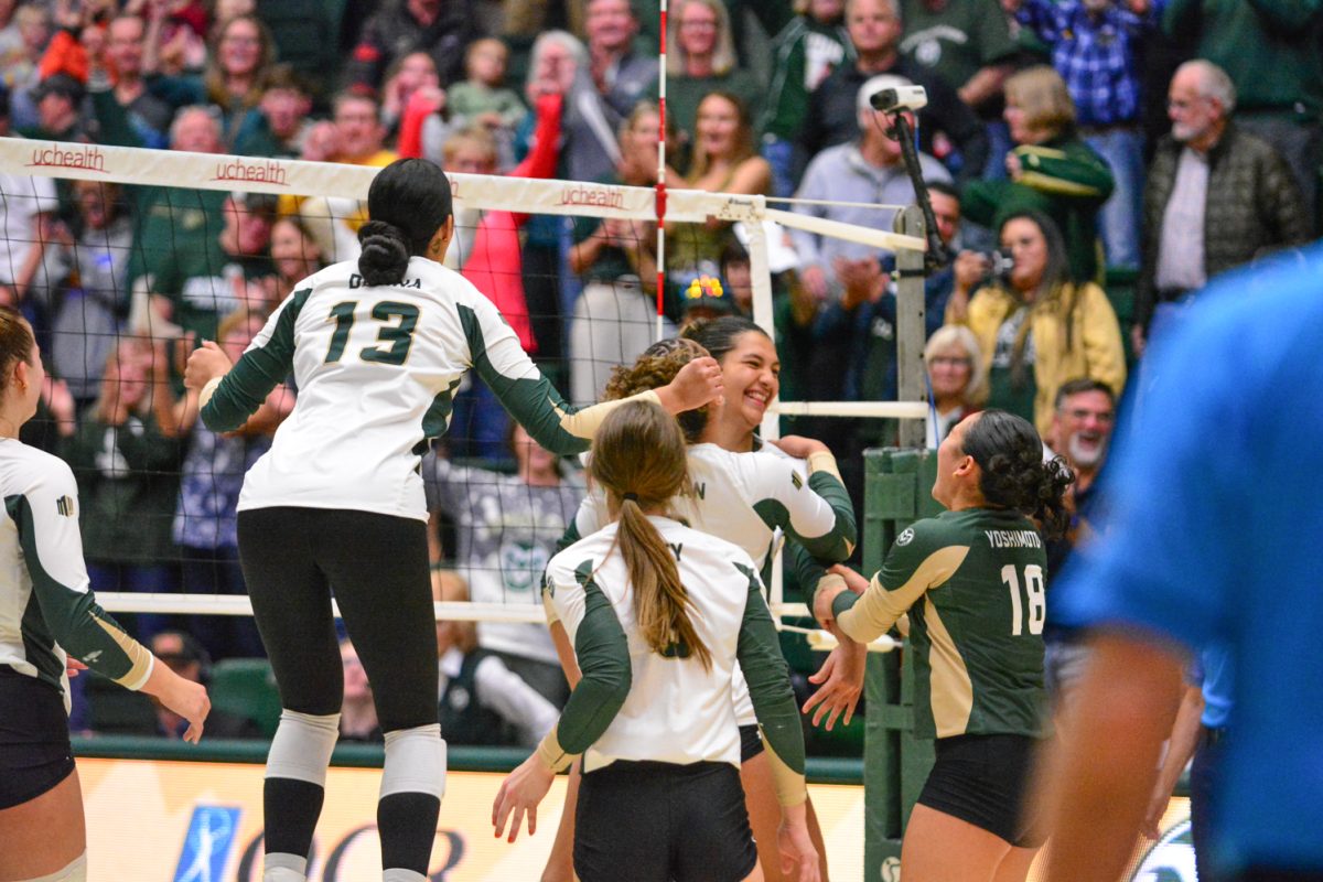 A group of girls in green and white jerseys celebrating