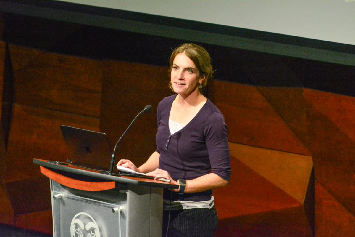 A woman talking into the microphone looking at the crowd