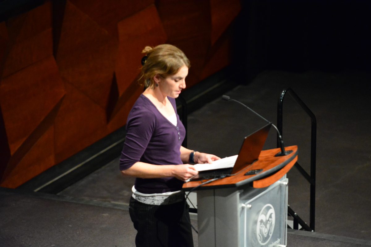 A woman looking at her notes on stage