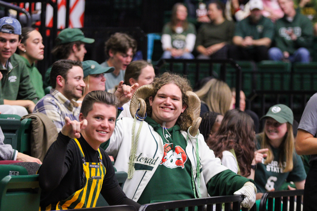 Two Colorado State fans hold up the ram hand sign.