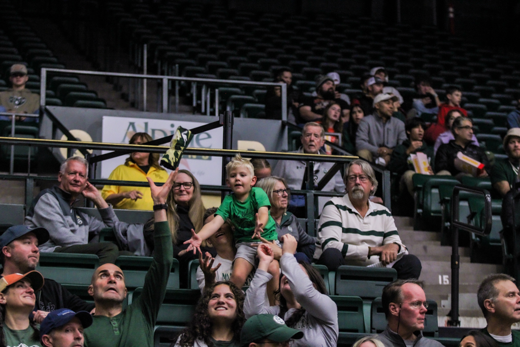 A young Colorado State fan attempts to catch a t-shirt thrown into the crowd.