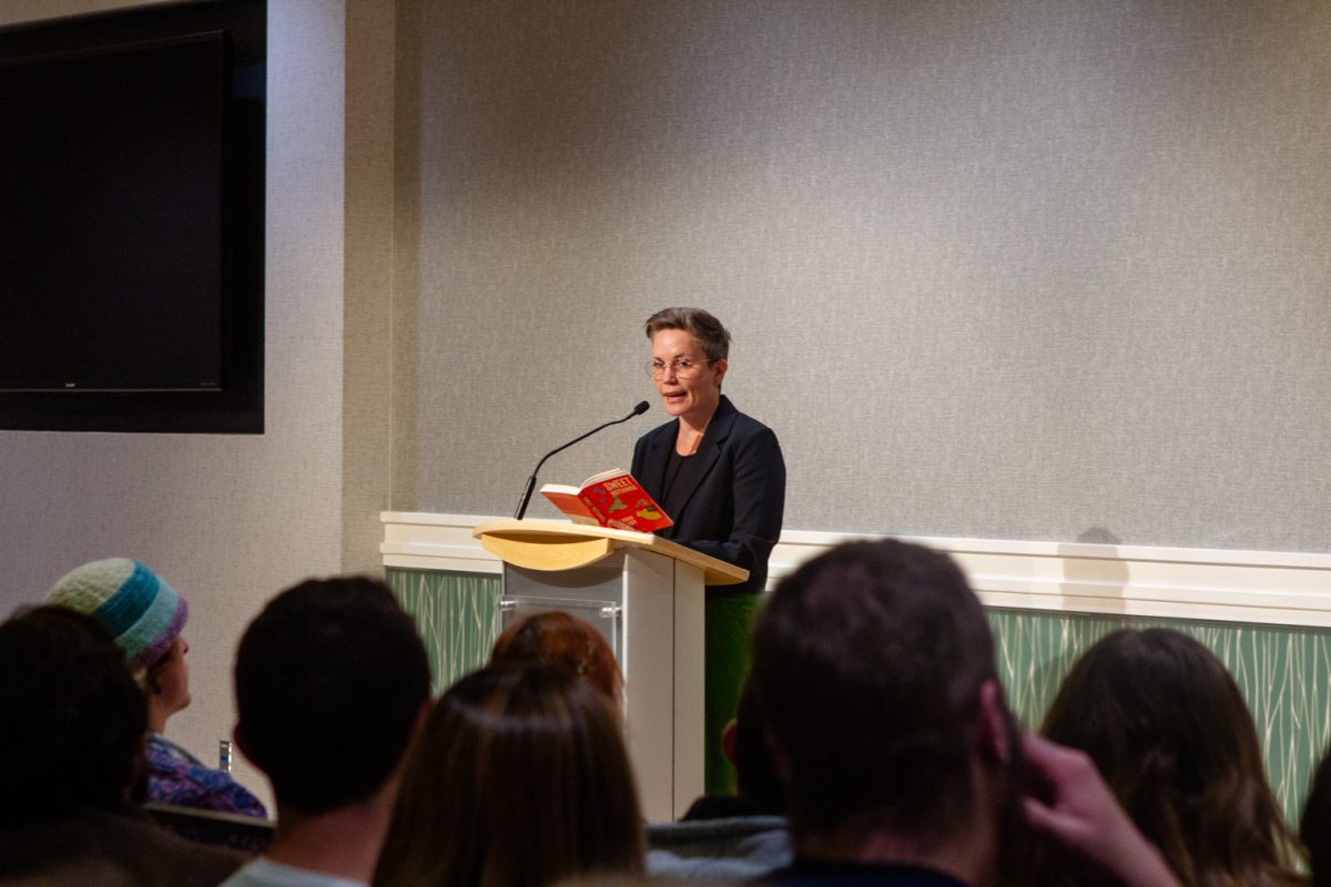 A person stands behind a podium and speaks to an audience.