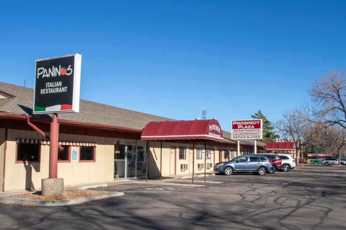 The outside of a building with a restaurant, laundromat, and offices.