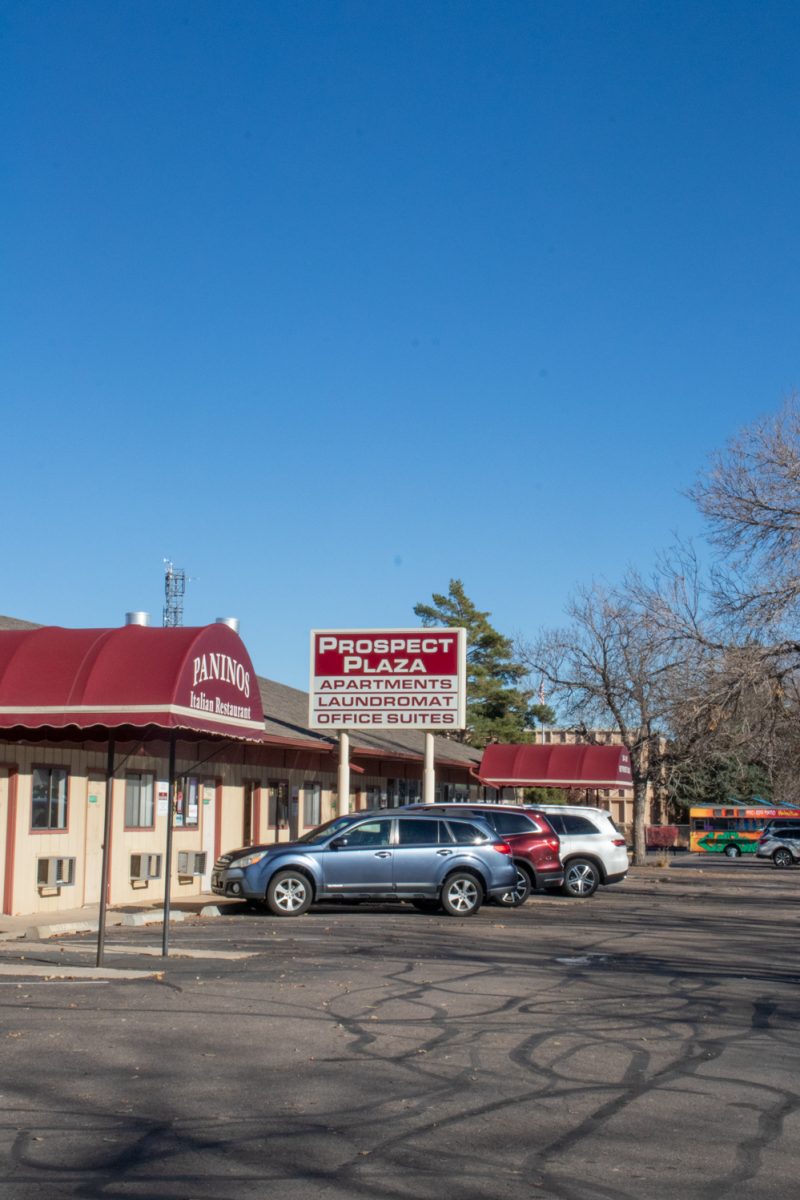The outside of a building with a restaurant, laundromat, and offices.