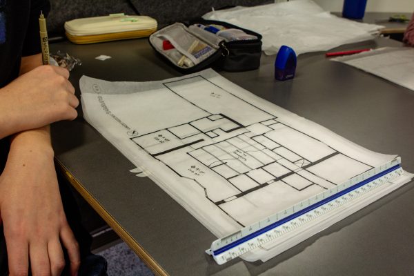 A thin piece of paper with design of a ceiling sits on a table.