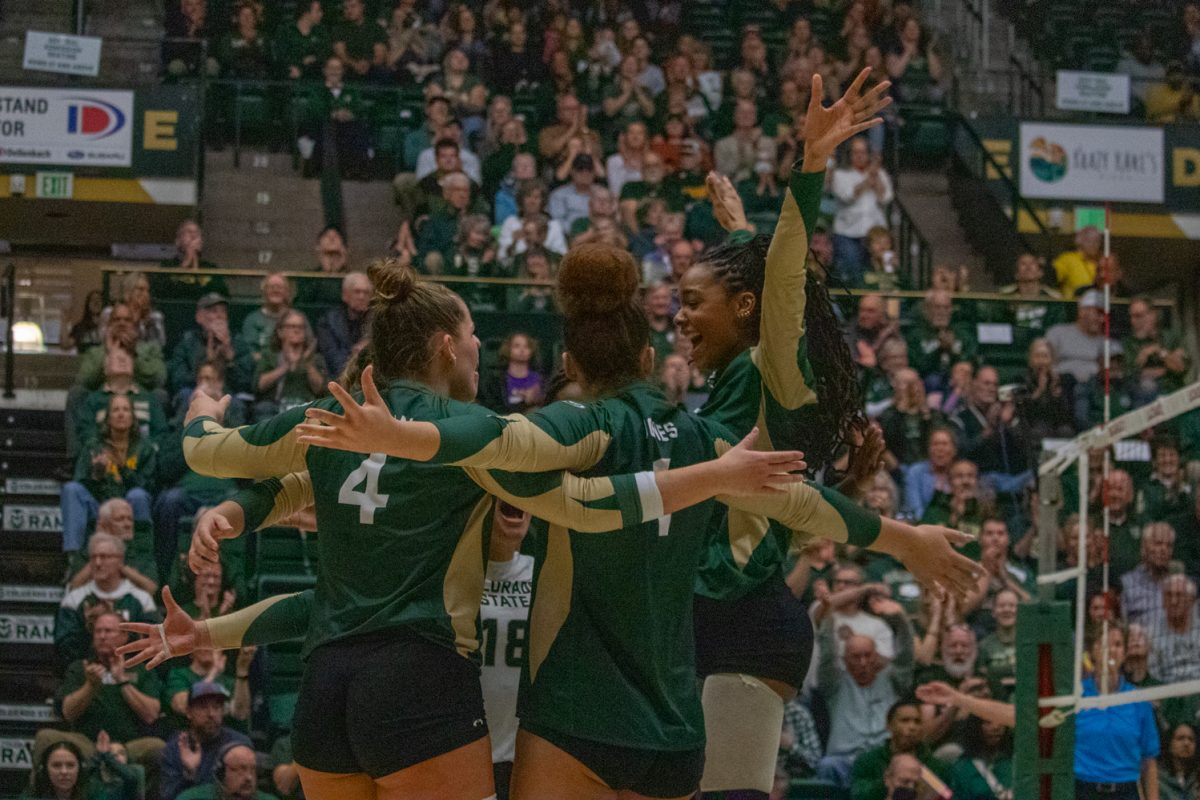 A volleyball team celebrates after scoring a point.